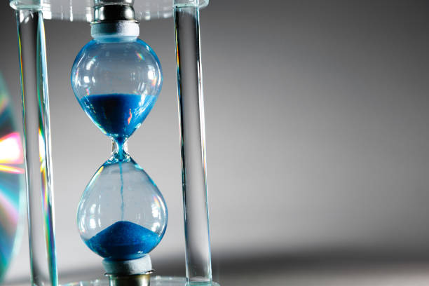 istock Blue hourglass on gray background close up 1311220088