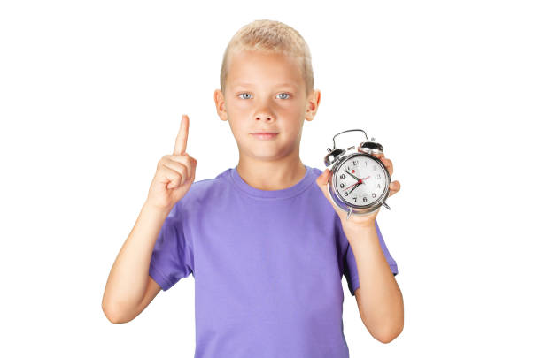school boy showing alarm clock - clock clock face blank isolated imagens e fotografias de stock