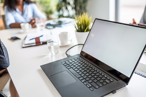 Row of laptops being prepared and set up for new employees in a company