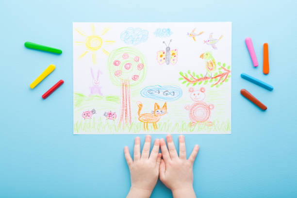 Baby hands, wax crayons and colorful draw of nature and different animals on light blue table background. Pastel color. Toddler development. Point of view shot. Closeup. Top down view. Baby hands, wax crayons and colorful draw of nature and different animals on light blue table background. Pastel color. Toddler development. Point of view shot. Closeup. Top down view. crayon photos stock pictures, royalty-free photos & images