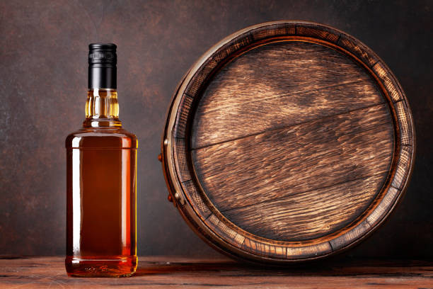Scotch whiskey bottle and old barrel Scotch whiskey bottle and old wooden barrel. With copy space bourbon whiskey photos stock pictures, royalty-free photos & images
