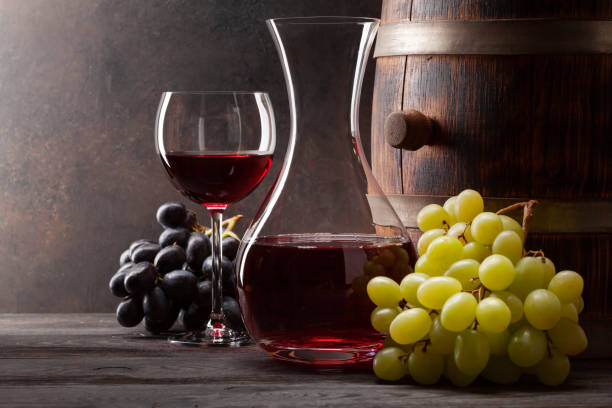 istock Wine decanter, glass and old wooden barrel 1311223360