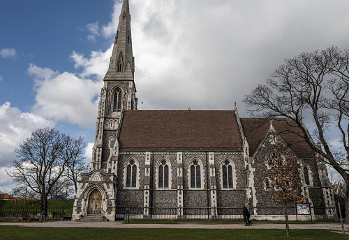 Brussels, Belgium - September 17, 2022: Church of Our Lady of the Sablon located in the historic centre of the city, is visible here on a cloudy day as seen from park side .