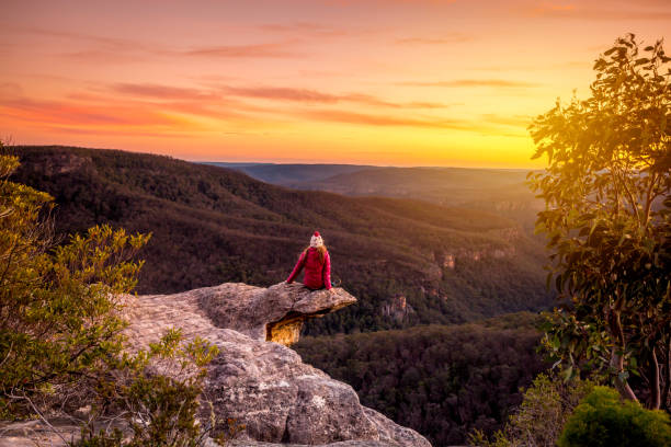 istock Woman watching sunset over mountains landscape 1311224470