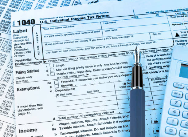 istock 1040 tax form, pen and calculator 1311225954