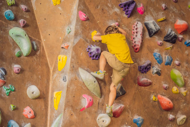 istock little boy climbing a rock wall in special boots. indoor 1311225986