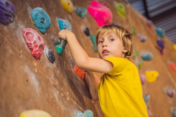 istock little boy climbing a rock wall in special boots. indoor 1311225993