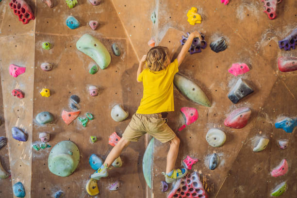 istock little boy climbing a rock wall in special boots. indoor 1311226016