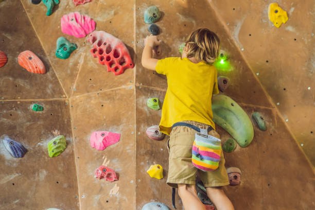 istock little boy climbing a rock wall in special boots. indoor 1311226080