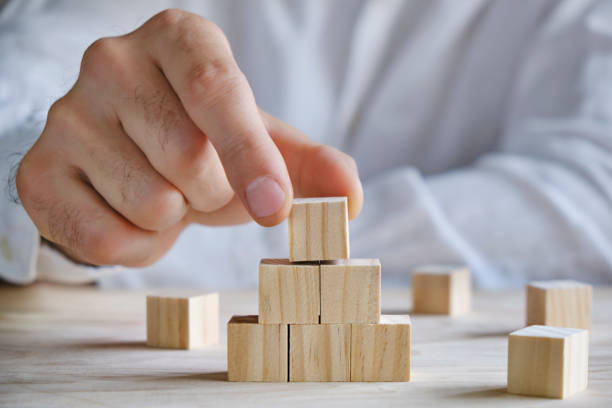 Men building a tower with wooden blocks, copy space for your text stock photo