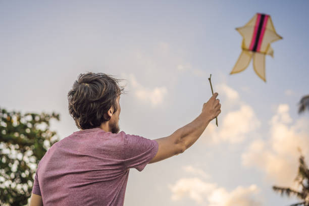 istock young men flying a kite at sunset on the beach 1311227280