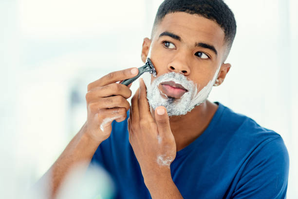 What a good time for the weekly shave Shot of handsome young man beginning to shave his face shaving stock pictures, royalty-free photos & images