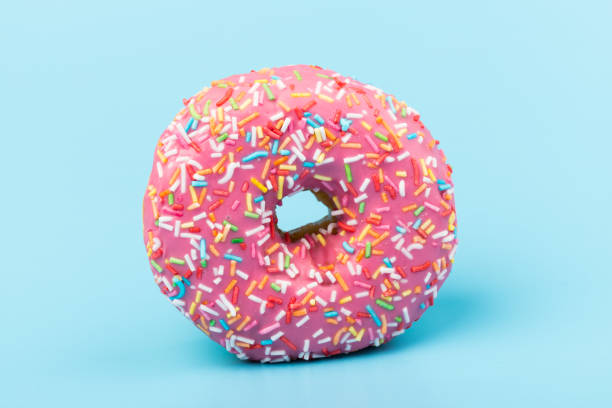 istock Fresh made Donuts isolated on blue background. Doughnuts are traditional sweet pastries. Copy space for text. 1311231589