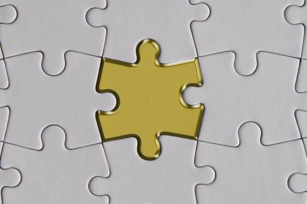 высовывая из толпы, золотой кусок головоломки в середине белых частей - jigsaw piece puzzle jigsaw puzzle metal стоковые фото и изображения
