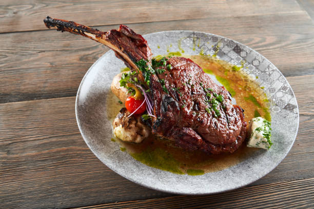 istock Modern roasted lamb on bone with garlic and sauce. 1311234502
