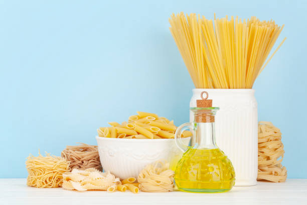 Various types of Italian pasta, olive oil and copy space