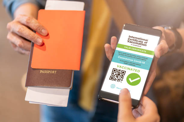istock Smartphone displaying a valid digital vaccination certificate passport for COVID-19 in male's hand, public area background. Vaccination, disease immunity passport, health and safty travel concepts 1311235717