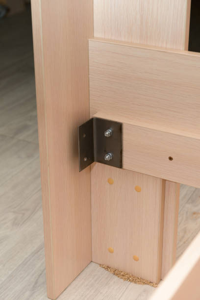 istock Assembling furniture with a metal corner. Chipboard panels are assembled together. 1311235996