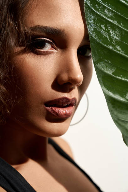 istock Woman hiding face behind big green leaf. 1311237695