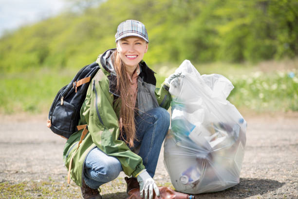 istock Woman picking up trash outdoor shot 1311239201