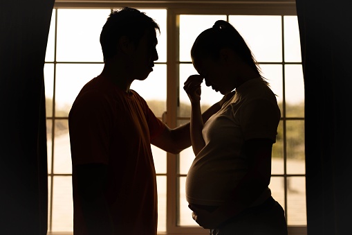 Un marido consolando a su estresada y preocupada esposa en casa. Embarazo y problemas de relación. depresión. photo