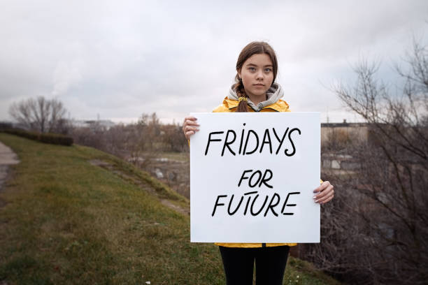 tiener die een affiche op klimaatverandering houdt - green friday stockfoto's en -beelden