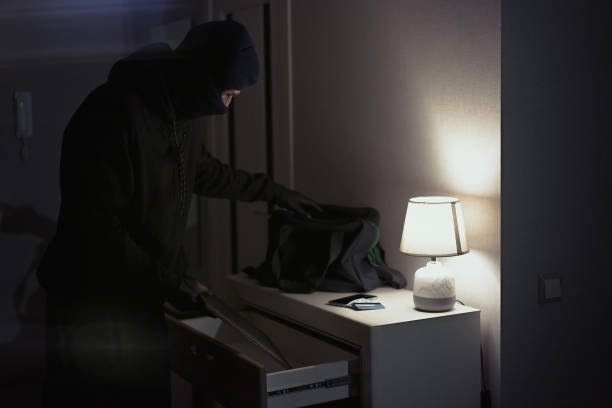 istock Burglar stealing laptop inside the house 1311242212
