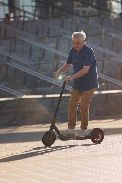 istock Senior riding electric scooter in the cityscape 1311242673