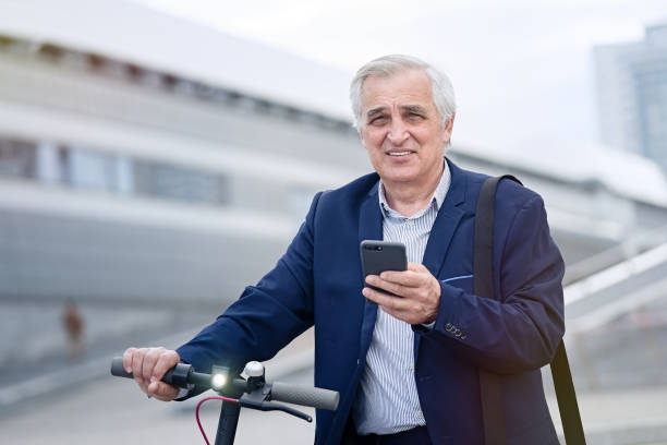 istock Businessman using phone on his electric scooter 1311242861