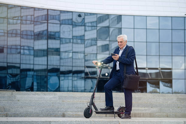 istock Businessman using phone on his electric scooter 1311242902