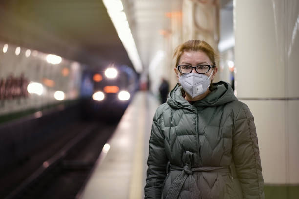 istock Woman in respirator mask waiting for train in platform 1311243228