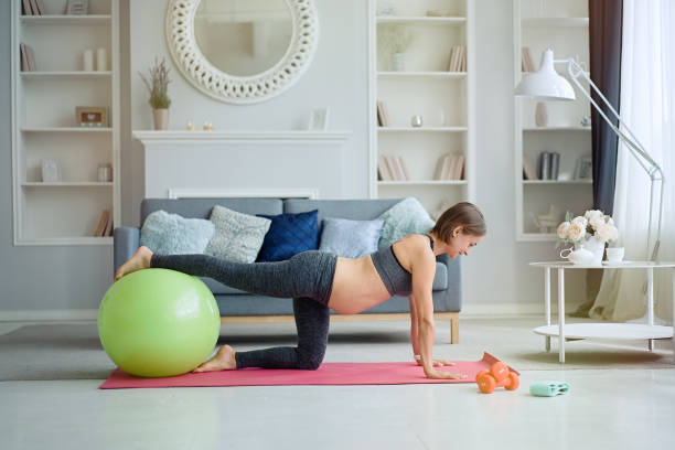 istock Pregnant woman exercising at home 1311243323
