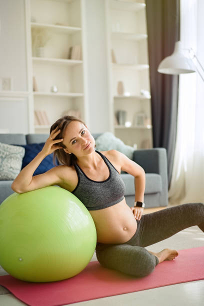 istock Pregnant woman exercising at home 1311243399