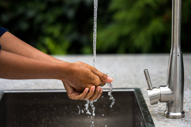 istock Woman washing her hands in sink 1311243652