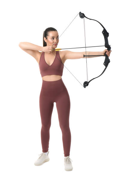 istock Sporty young woman practicing archery on white background 1311243767