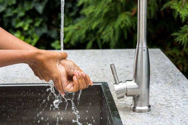 istock Woman washing her hands in sink 1311244585