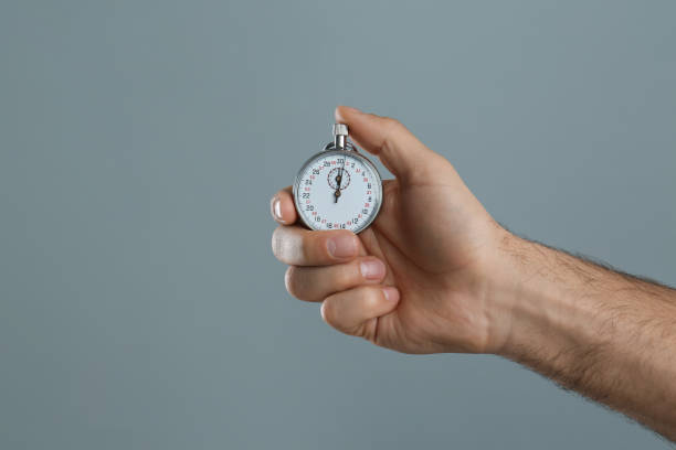 istock Man holding vintage timer on grey background, closeup 1311244747