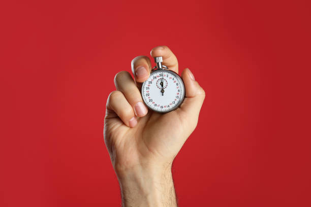 istock Man holding vintage timer on red background, closeup 1311244754