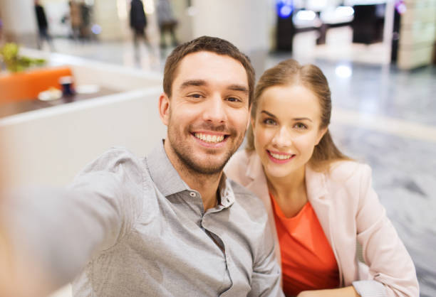 istock happy couple taking selfie in mall or office 1311244762