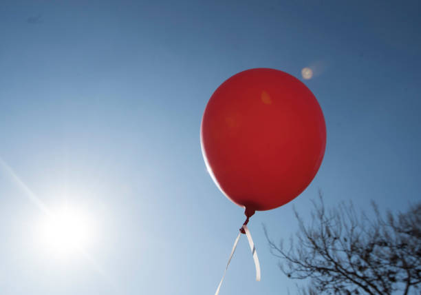 istock red balloon and blue sky background with sun 1311245161