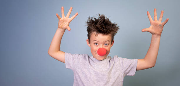 istock cool boy with wild hair posing with red clown nose on blue background 1311247607