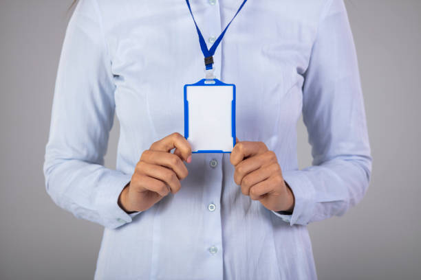 femme retenant la carte d’identité en plastique blanc blanc d’identification - id card business card holding human hand photos et images de collection