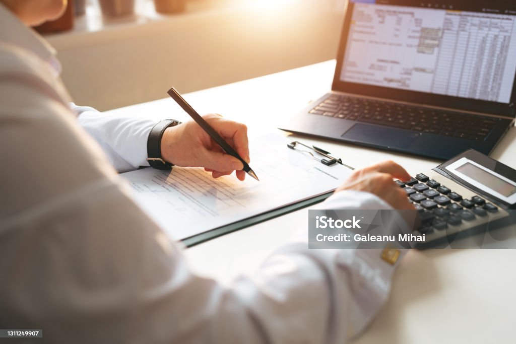 Businessman calculating the financial statement of his business. Business panoramic  banner with  copy space. Accounting and Tax. Businessman calculating the financial statement of his business. Business panoramic  banner with 
copy space. Accounting and Tax Tax Stock Photo