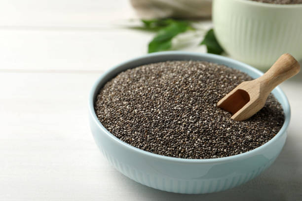 istock Bowl with chia seeds and wooden scoop on white table. Space for text 1311250218