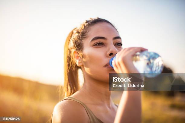 African Woman Drinking Clean Water After Doing Sport Stock Photo - Download Image Now