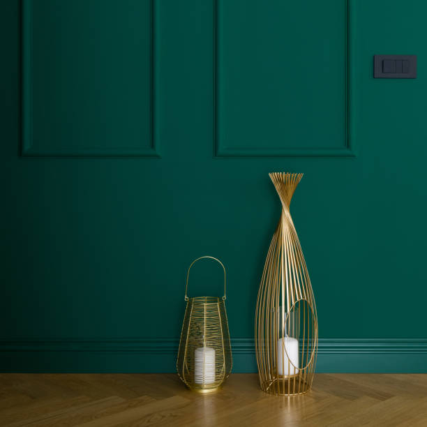 Golden decorations and emerald green wall Elegant emerald green wall with molding and two, golden decorative candlesticks on wooden floor moulding trim photos stock pictures, royalty-free photos & images
