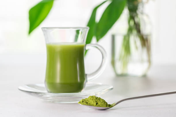 istock Japanese green tea Matcha in a glass cup  with coconut milk on a white kitchen table. 1311253507