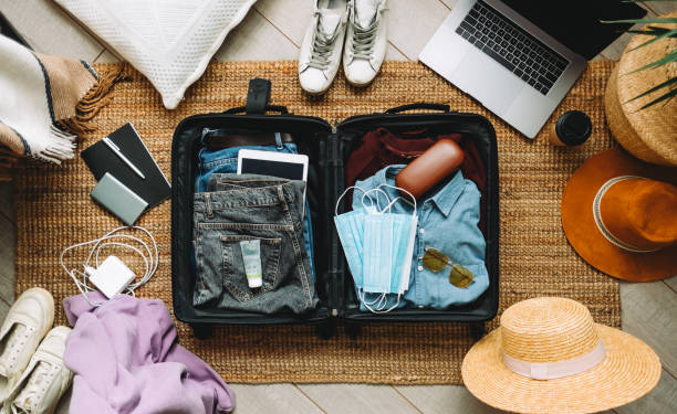 valise d’emballage pour les vacances de voyage dans la nouvelle normale, vue du haut. - voyage photos et images de collection