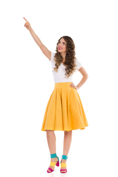 istock Beautiful Young Woman Is Looking Up And Pointing 1311255561
