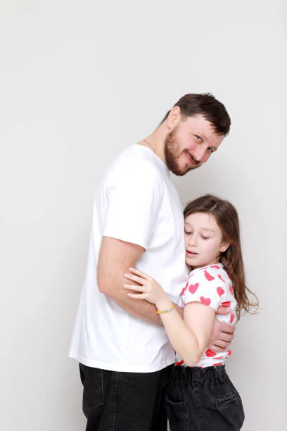 istock father's day. side view affectionate little child daughter is hugging smiling bearded father. Happy small kid girl enjoying sweet moment with dad on white background trustful relations. 1311256774